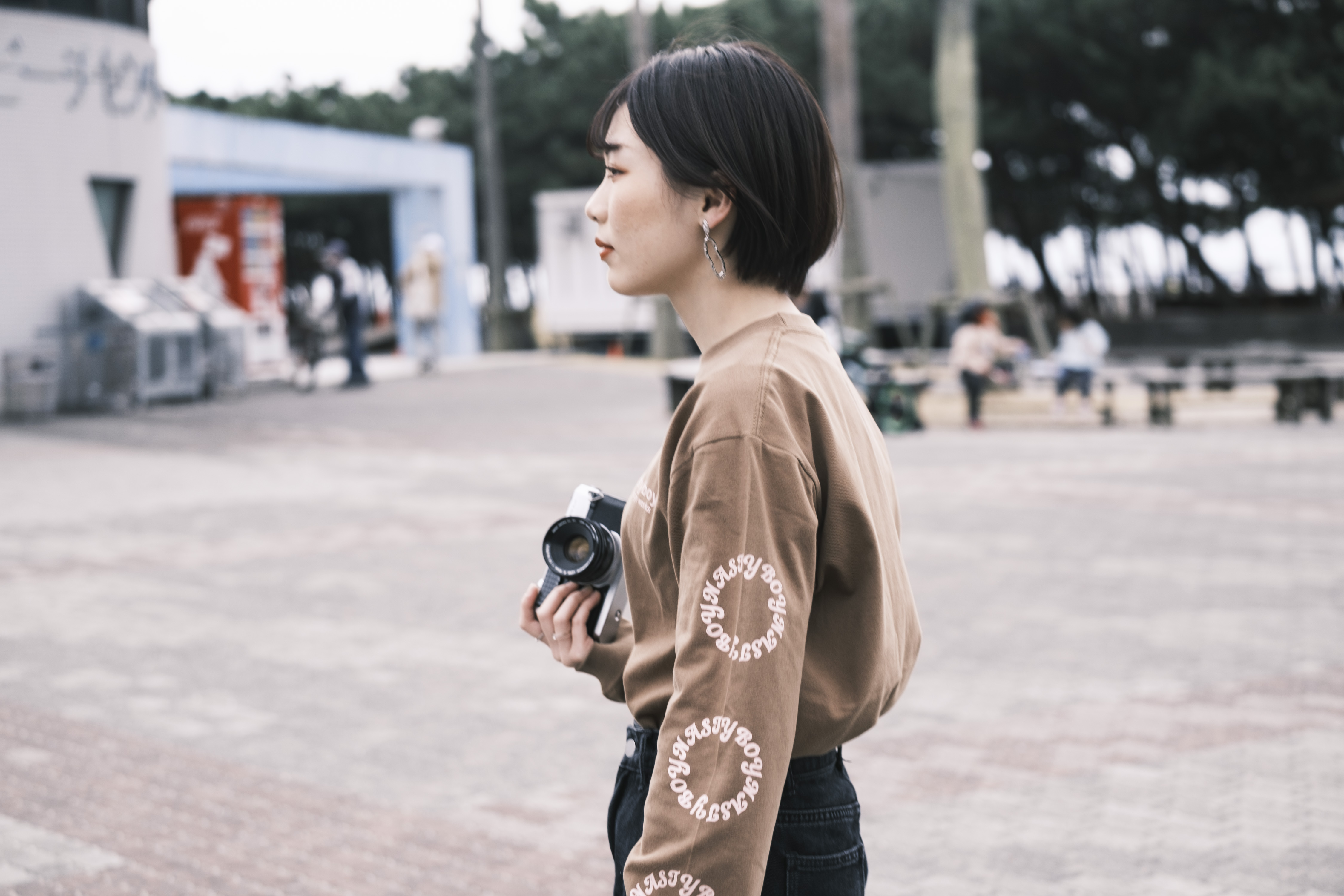 横向きでカメラを持つ女性