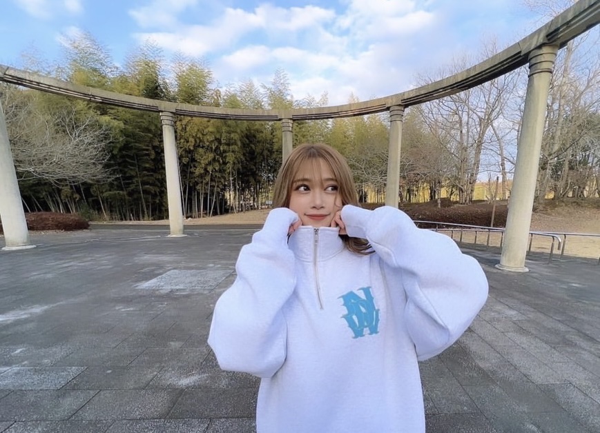 ハーフジップスウェットを着る女性